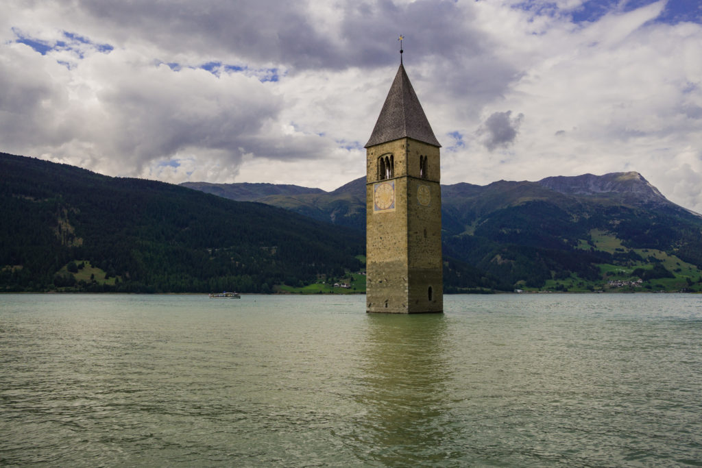 Das Bild zeigt eines der Wahrzeichen des Vinschgaus - den Reschensee mit altem Kirchturm.