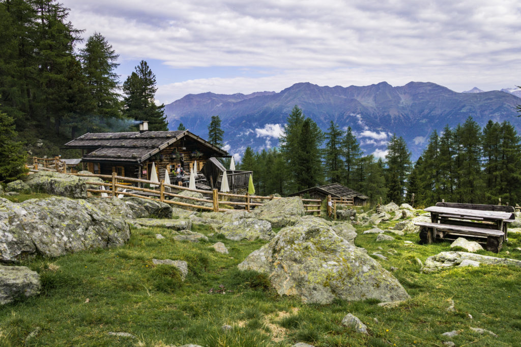 Das Foto zeigt die Latschinger Alm vor einem schönen Bergpanorama.